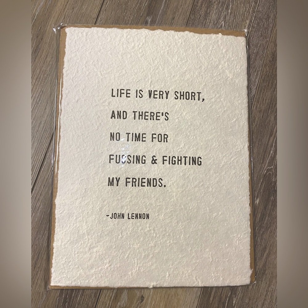 New displays a quote attributed to John Lennon, printed on handmade paper